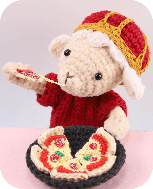 王さま(立体の編みぐるみ)がピザを食べている画像