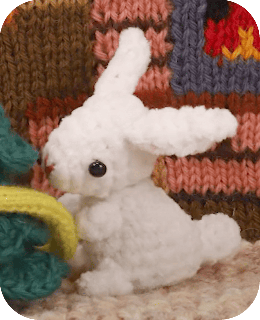 しろうさ(立体の編みぐるみ)がクリスマスツリーの飾りつけをしている画像